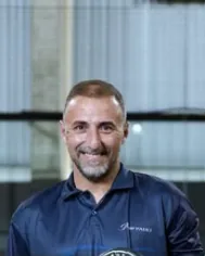 Professor Eduardo Pereira, sorrindo, com a camisa da Prime Padel, na quadra.